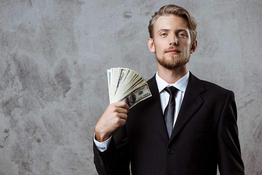 A business man in suits holding money